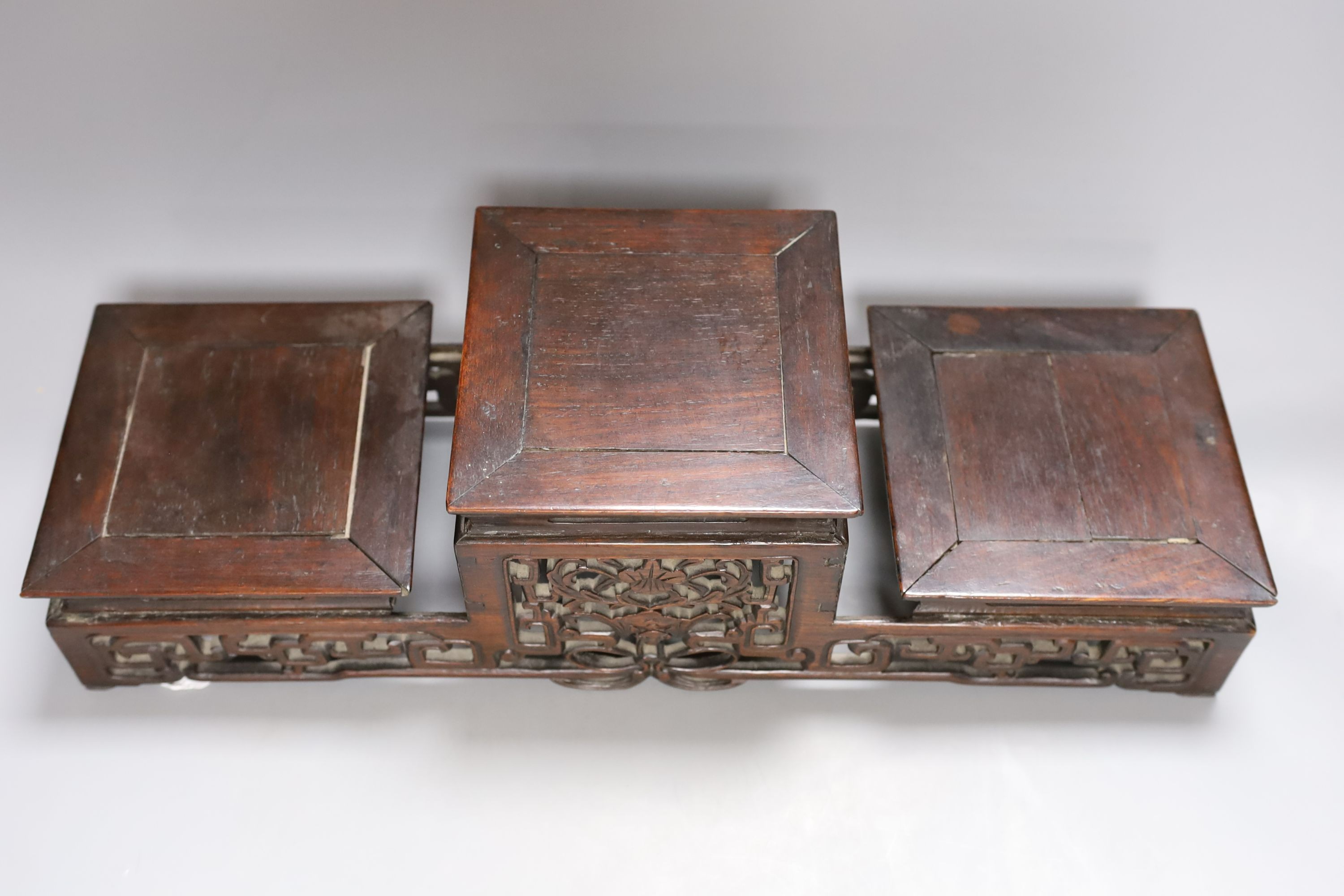 A Chinese carved hardwood 3 tier stand, late Qing, together with other similar stands. Largest 49cm